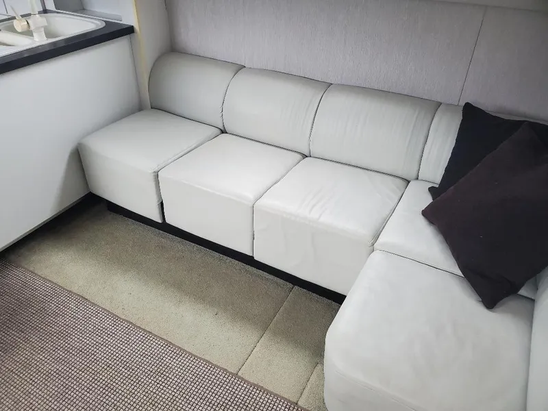 Slide: The Image of White leather sofa in 1990 Mainship Mediterranean yacht interior, with black cushions. - 7