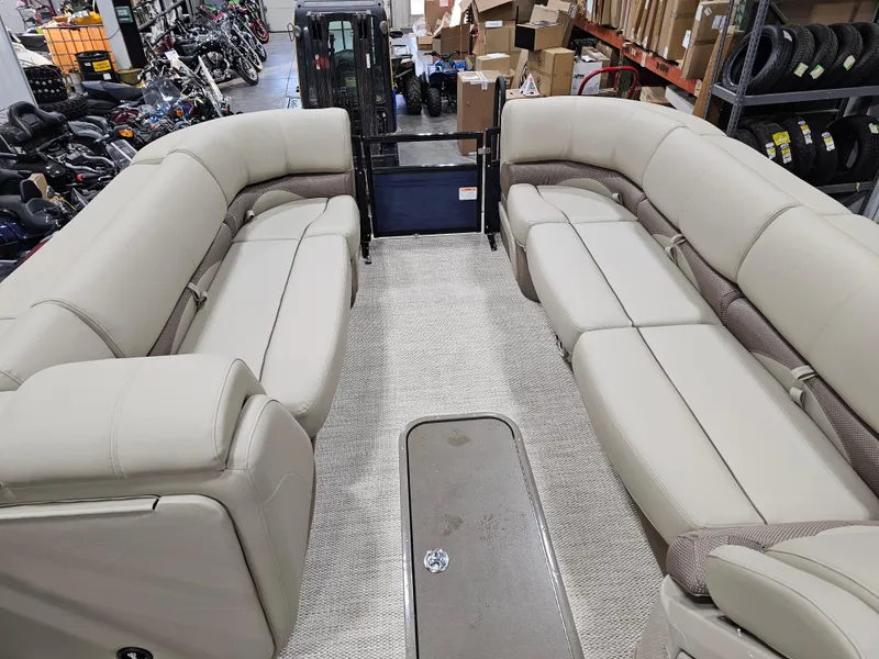 Slide: The Image of 2024 Regency 250 DL3 pontoon boat interior with beige seating in a showroom. - 10