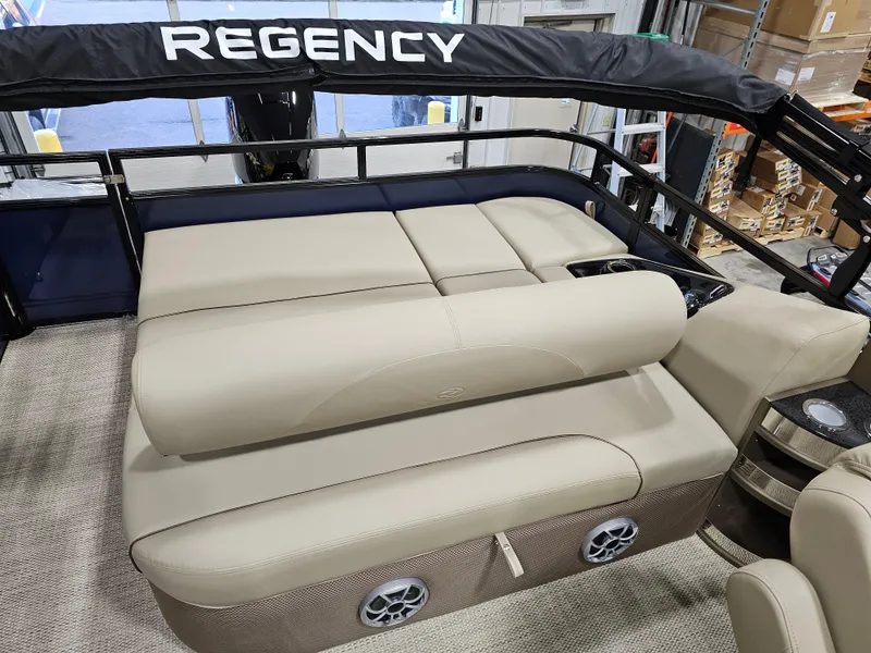 Slide: The Image of 2024 Regency 250 DL3 pontoon boat with beige seating and black canopy. - 6