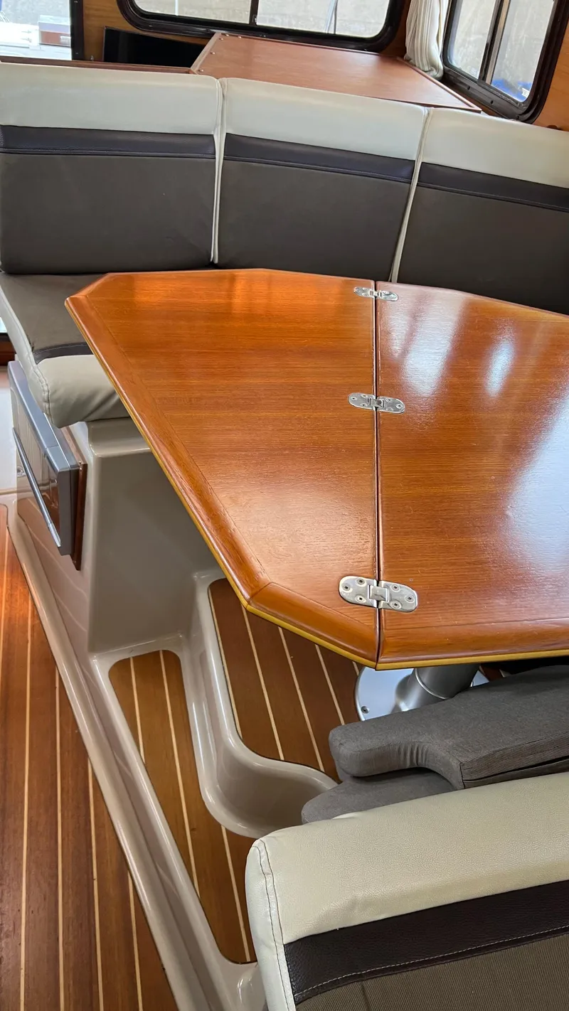 Slide: The Image of Interior of 2014 Ranger Tugs R29S with wooden table and cushioned seating. - 11