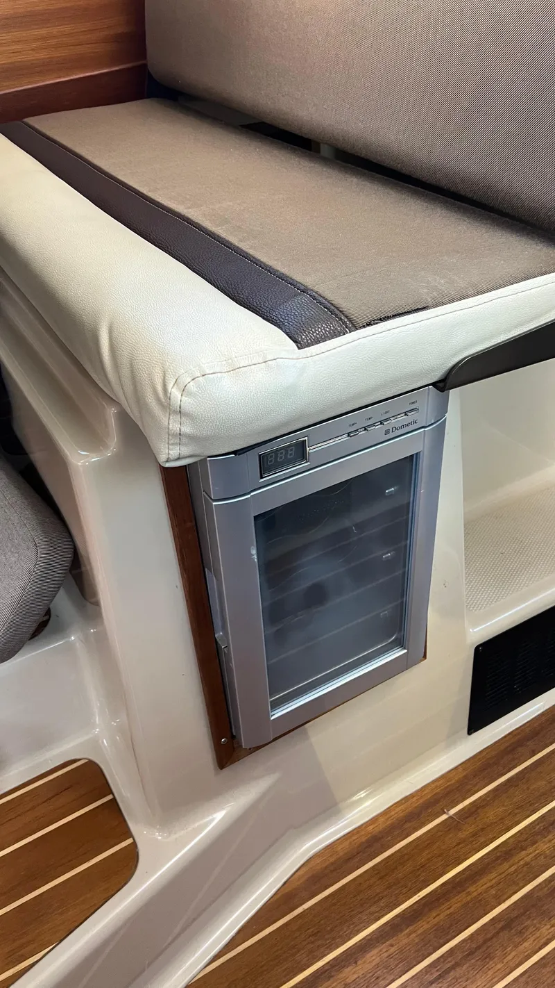 Slide: The Image of 2014 Ranger Tugs R29S interior with built-in mini fridge and cushioned seating. - 15