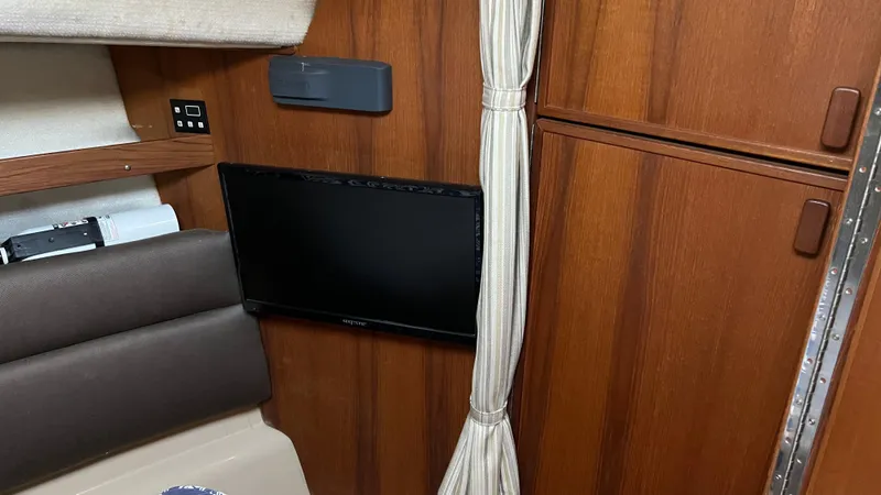 Slide: The Image of 2014 Ranger Tugs R29S interior with mounted TV and wooden cabinetry. - 18