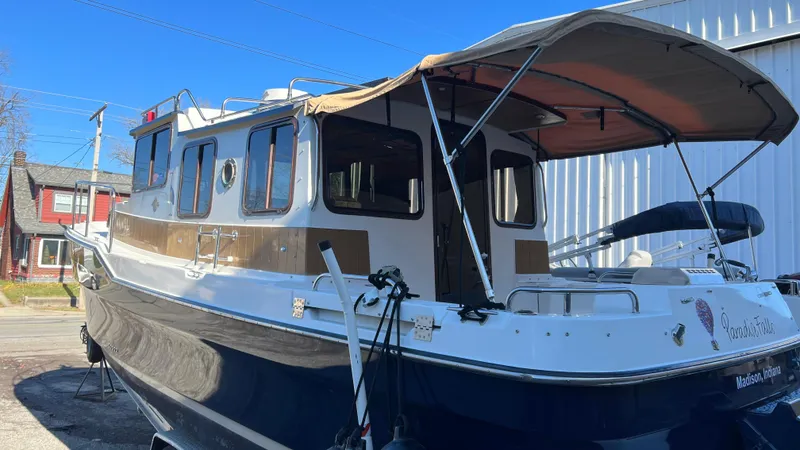 Slide: The Image of 2014 Ranger Tugs R29S boat with canopy, docked outdoors on a sunny day. - 2