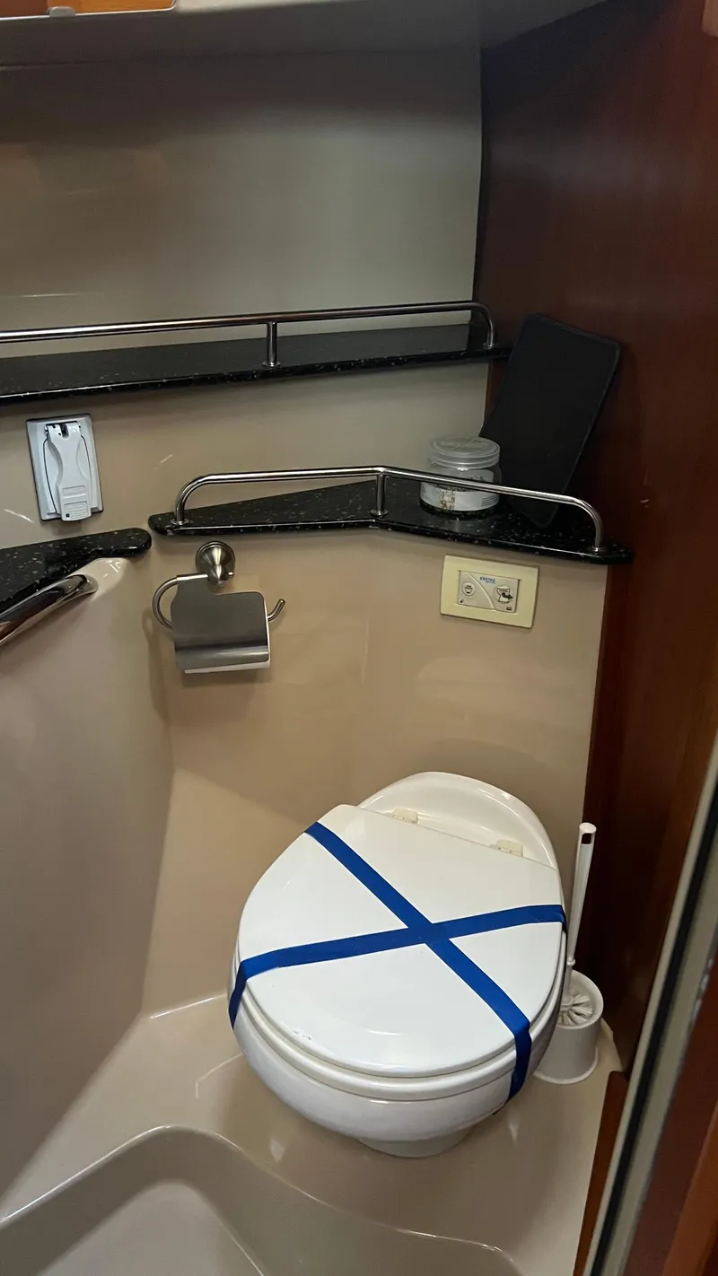 Slide: The Image of 2014 Ranger Tugs R29S boat bathroom with toilet and storage shelves. - 21