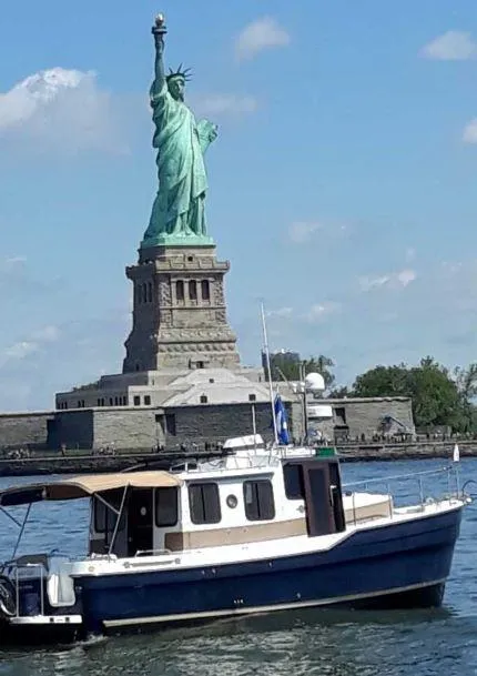 Slide: The Image of 2014 Ranger Tugs R29S boat near Statue of Liberty on a sunny day. - 3