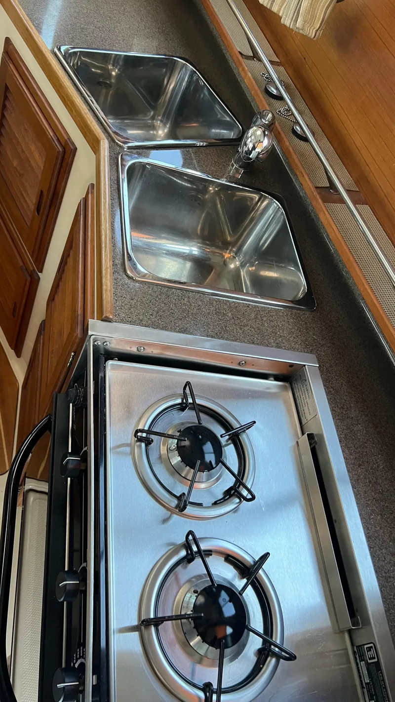 Slide: The Image of 2014 Ranger Tugs R29S kitchen with dual sinks and a two-burner stove. - 30