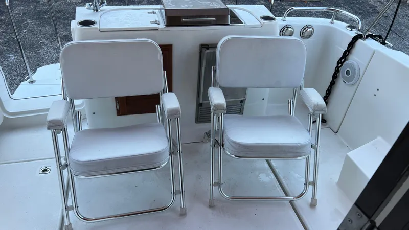 Slide: The Image of 2014 Ranger Tugs R29S boat deck with two white chairs. - 33