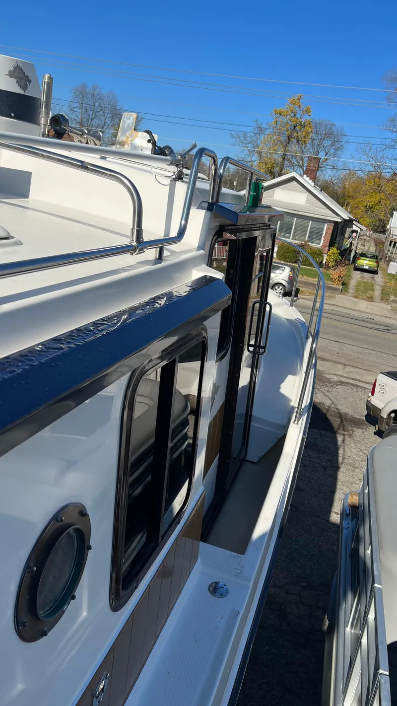 Slide: The Image of 2014 Ranger Tugs R29S boat docked in a residential area, side view. - 49