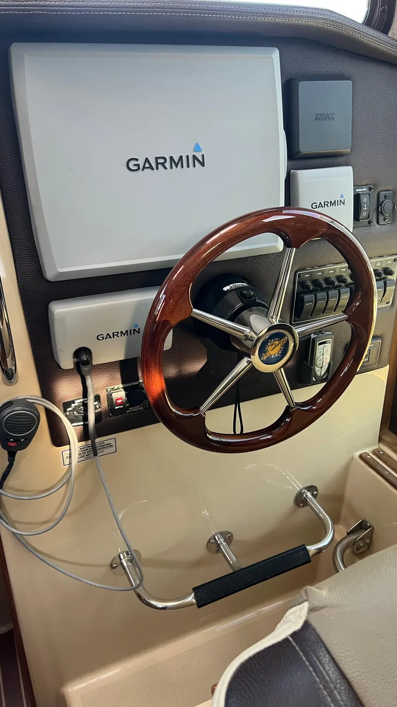 Slide: The Image of 2014 Ranger Tugs R29S helm with Garmin navigation system and wooden steering wheel. - 7