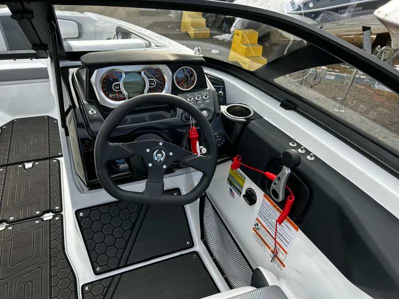 Slide: The Image of 2024 Scarab 215 Wake LE boat dashboard with steering wheel and control panel. - 18