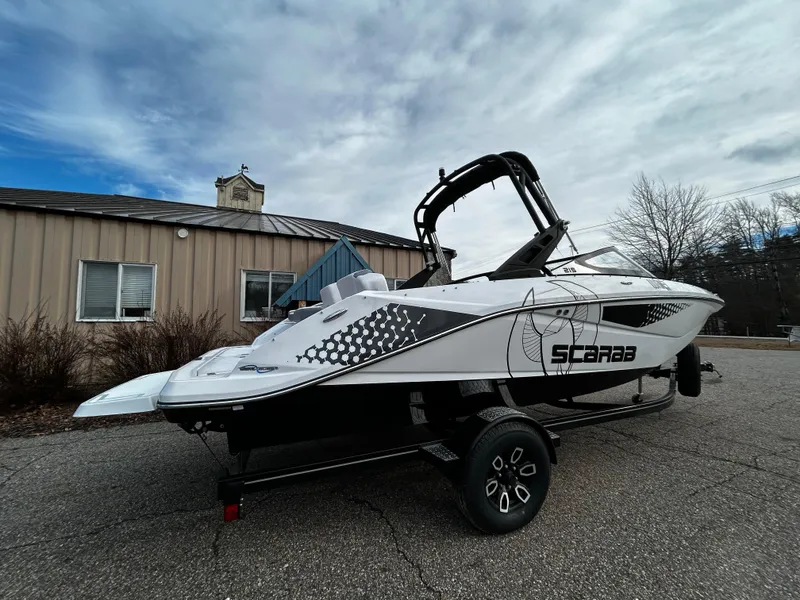 Slide: The Image of 2024 Scarab 215 Wake LE boat on a trailer outside a building. - 34