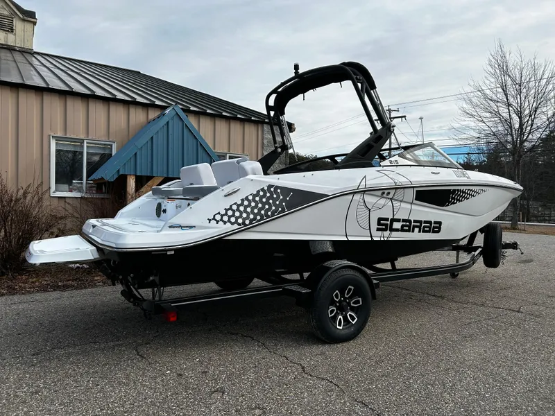 Slide: The Image of 2024 Scarab 215 Wake LE boat on trailer, parked outdoors. - 35