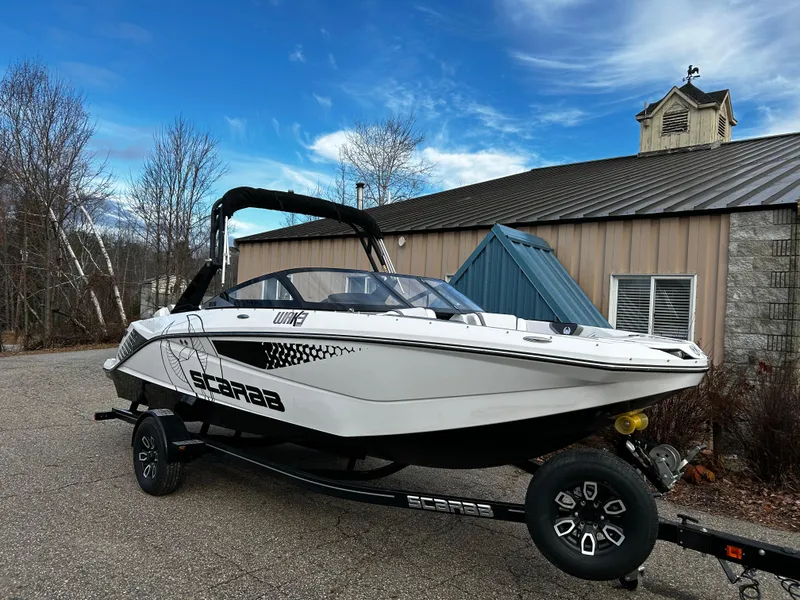 Slide: The Image of 2024 Scarab 215 Wake LE boat on trailer outside a building. - 36