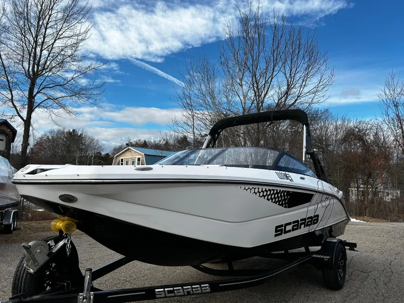 Slide: The Image of 2024 Scarab 215 Wake LE boat on trailer, parked outdoors. - 39