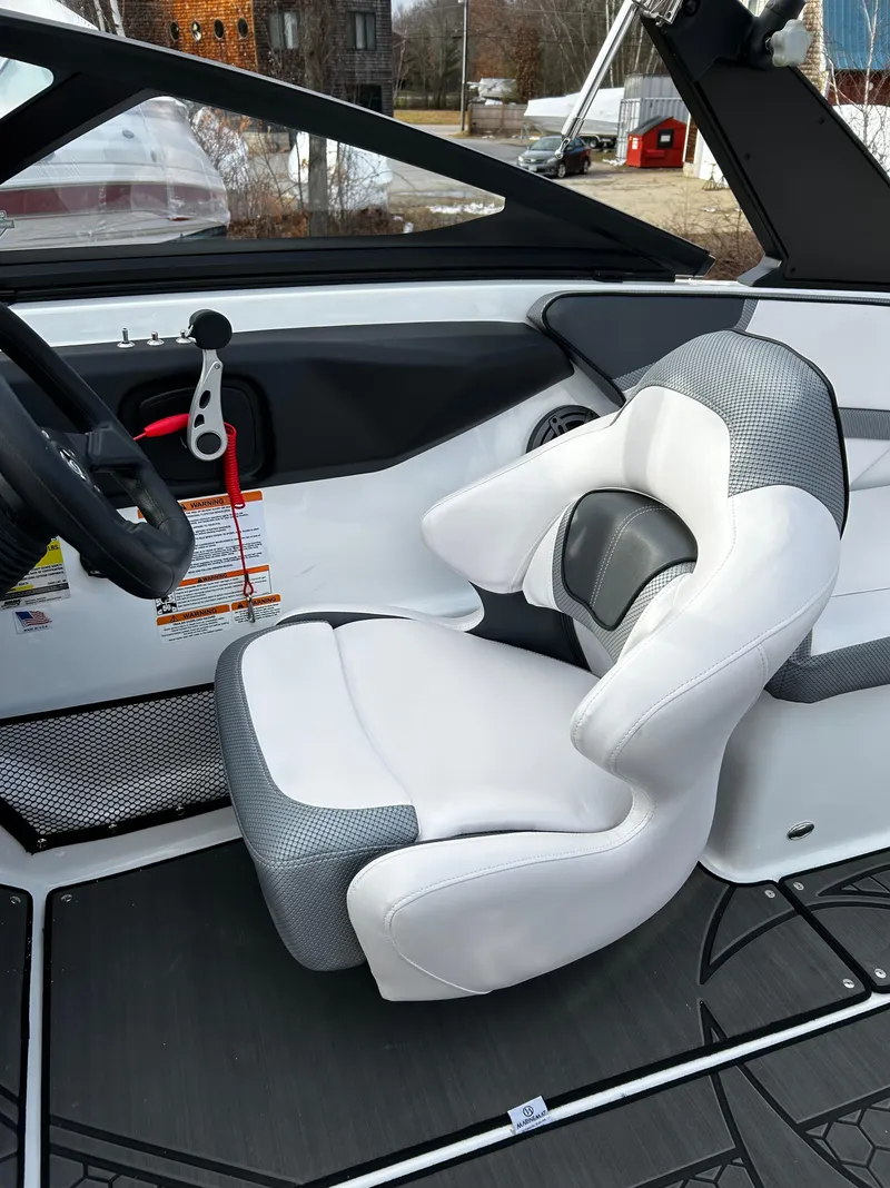 Slide: The Image of 2024 Scarab 215 Wake LE boat interior with white and gray captain's seat. - 46