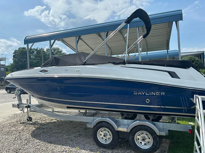 Slide: The Image of 2024 Bayliner VR6 boat on a trailer under a canopy. - 2