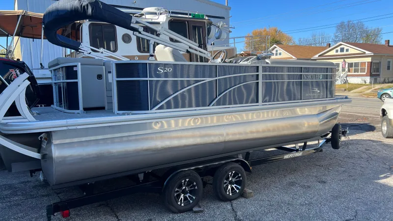 Slide: The Image of 2021 Bennington S20 pontoon boat on a trailer in a residential area. - 0