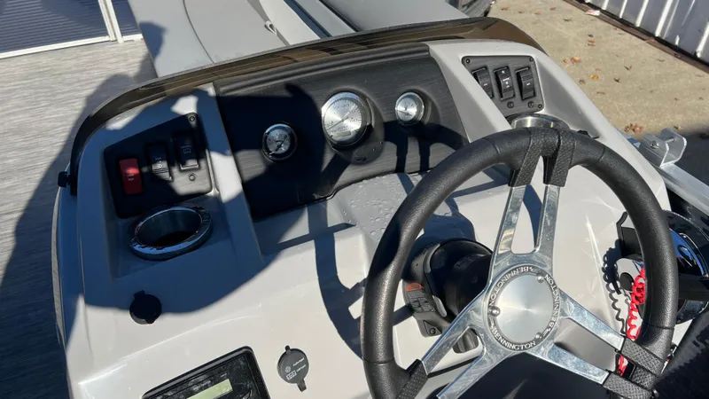 Slide: The Image of 2021 Bennington S20 boat dashboard with steering wheel, gauges, and control switches. - 12