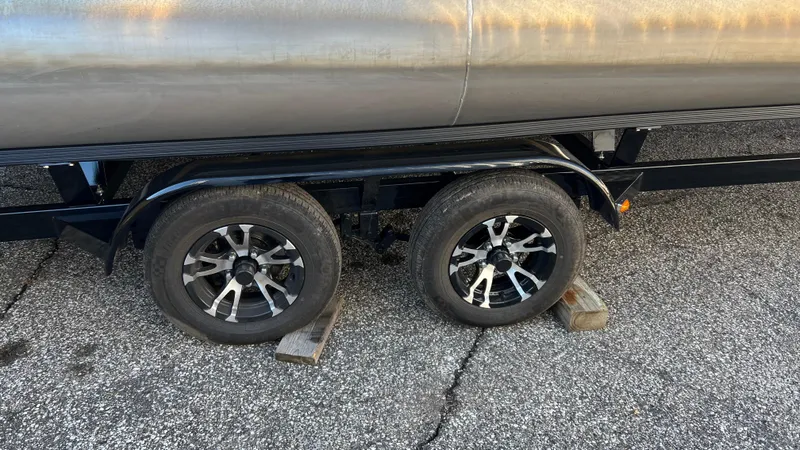 Slide: The Image of Bennington S20 2021 trailer wheels on asphalt with wooden blocks. - 19