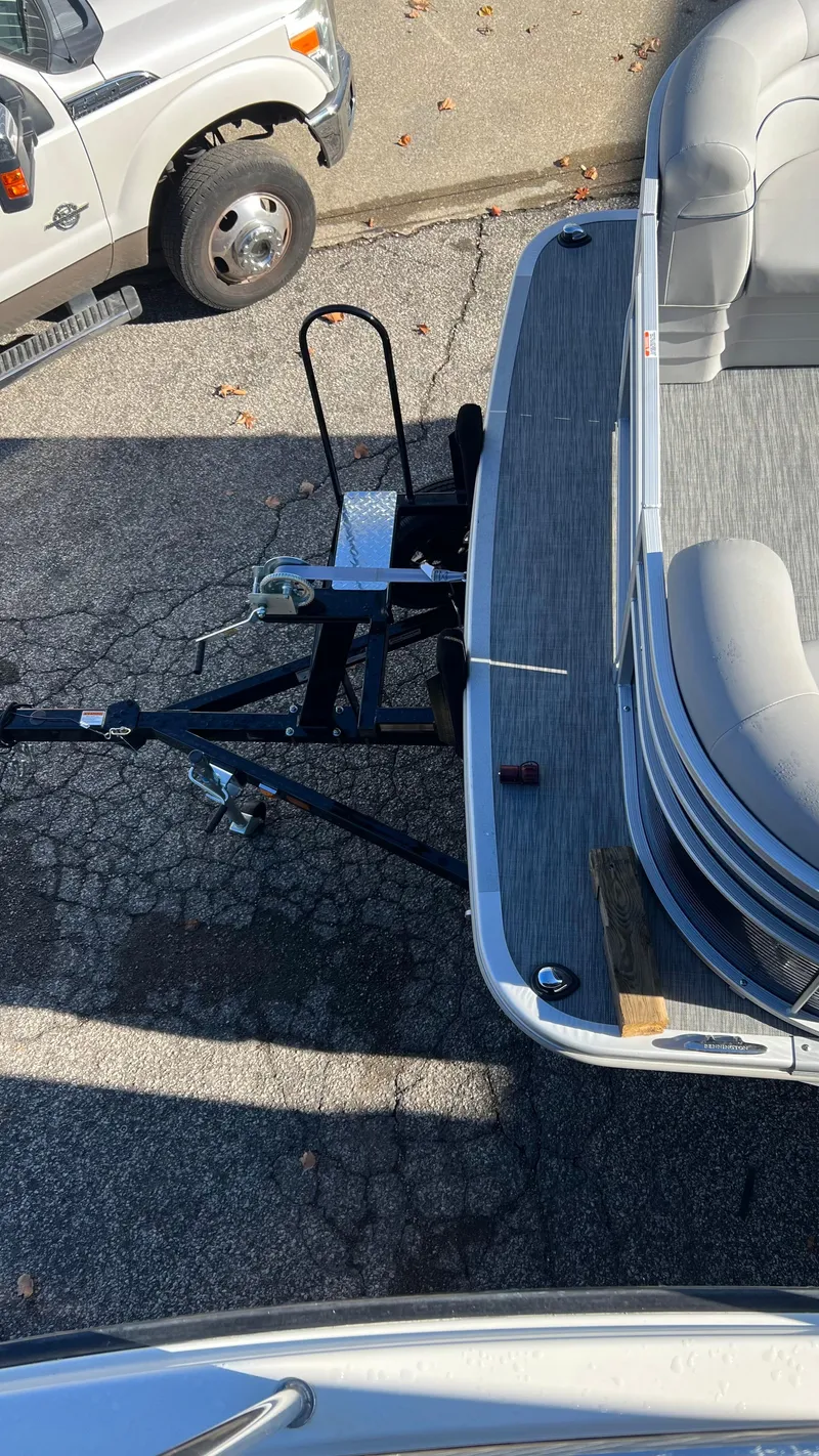 Slide: The Image of 2021 Bennington S20 pontoon boat on trailer, parked next to a white truck. - 8