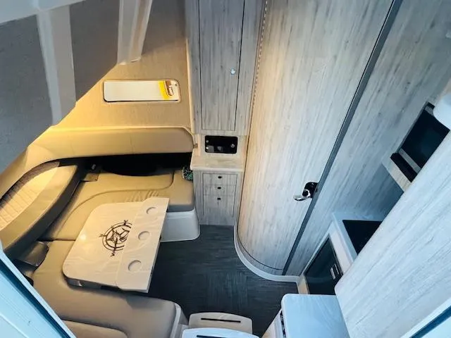 Slide: The Image of 2024 Regulator 41 boat cabin interior with seating, table, and kitchenette. - 16