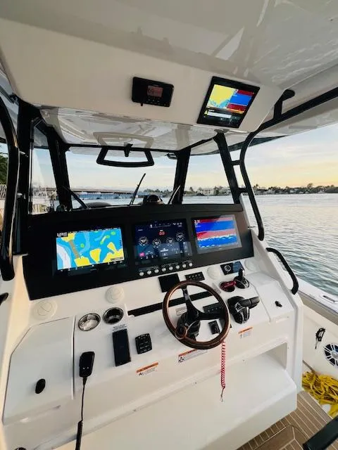Slide: The Image of 2024 Regulator 41 boat helm with advanced navigation systems and waterfront view. - 25