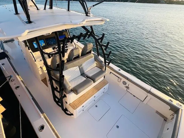 Slide: The Image of 2024 Regulator 41 boat with seating and fishing rod holders on a calm water body. - 8