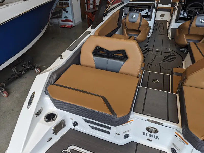 Slide: The Image of 2024 Scarab 235 ID boat interior with tan and gray seating, modern design. - 11