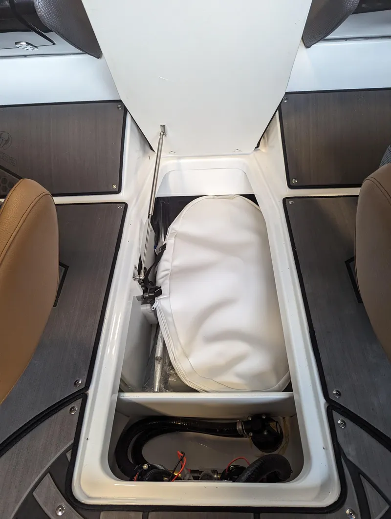 Slide: The Image of 2024 Scarab 235 ID boat storage compartment with white cover and mechanical components. - 12
