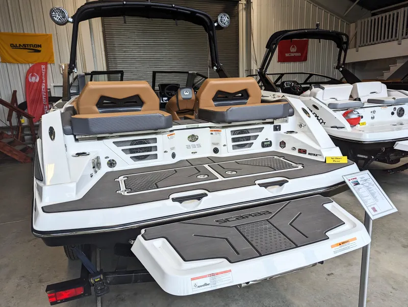 Slide: The Image of 2024 Scarab 235 ID boat displayed in a showroom, rear view. - 14