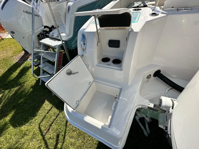 Slide: The Image of 2024 Sailfish 226 DC boat with open storage compartment and visible Mercury engine. - 12