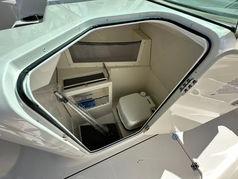 Slide: The Image of 2024 Sailfish 226 DC boat interior storage compartment with portable toilet. - 14