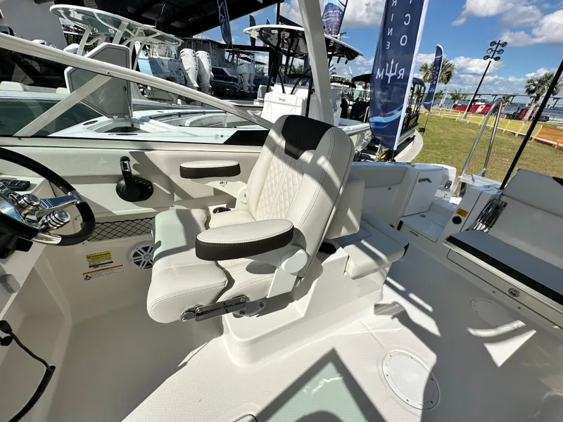 Slide: The Image of 2024 Sailfish 226 DC boat interior with white seating and steering wheel. - 16