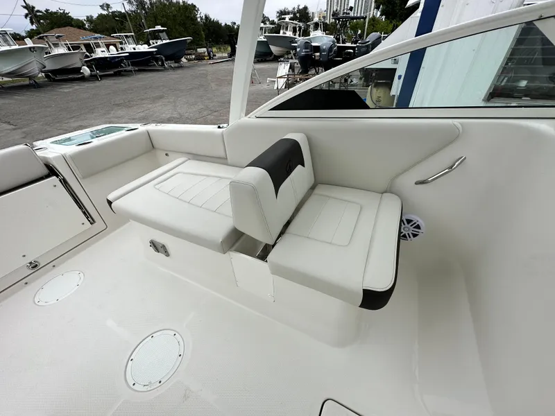 Slide: The Image of 2024 Sailfish 226 DC boat interior seating area with white and black upholstery. - 30
