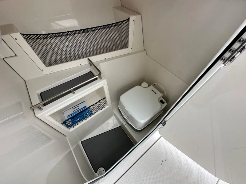 Slide: The Image of 2024 Sailfish 226 DC boat interior with compact toilet and storage compartments. - 31
