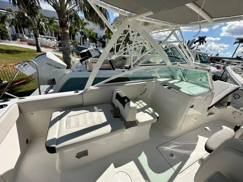 Slide: The Image of 2024 Sailfish 226 DC boat interior with seating and helm, under sunny skies. - 5
