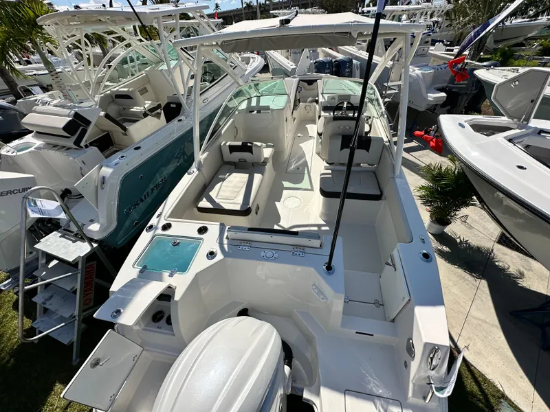 Slide: The Image of 2024 Sailfish 226 DC boat interior with seating and controls, displayed at a boat show. - 7