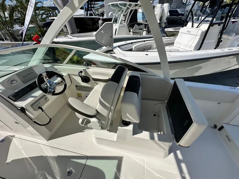 Slide: The Image of 2024 Sailfish 226 DC boat interior with steering wheel and seating. - 8