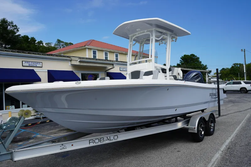 Slide: The Image of 2024 Robalo 226 Cayman boat on trailer outside dealership. - 1