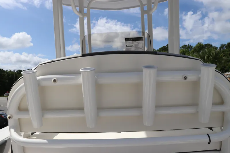Slide: The Image of 2024 Robalo 226 Cayman boat with rod holders and T-top against blue sky. - 13