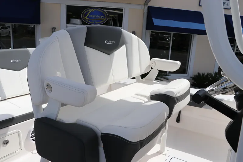 Slide: The Image of 2024 Robalo 226 Cayman boat seating with white and gray cushioned seats. - 16