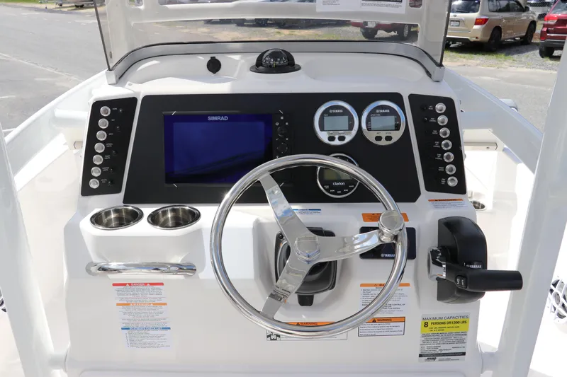 Slide: The Image of 2024 Robalo 226 Cayman boat dashboard with steering wheel and navigation controls. - 17