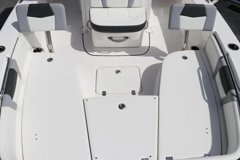 Slide: The Image of 2024 Robalo 226 Cayman boat interior, white seating and storage compartments. - 19