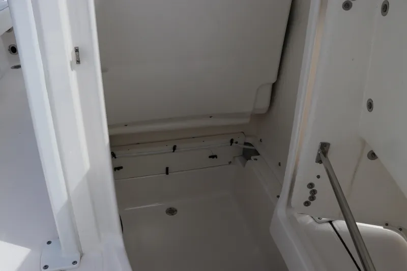 Slide: The Image of 2024 Robalo 226 Cayman boat storage compartment with white interior. - 21