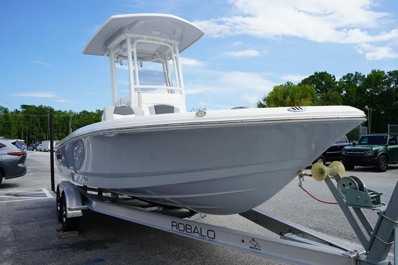Slide: The Image of 2024 Robalo 226 Cayman boat on trailer in parking lot, clear sky background. - 3
