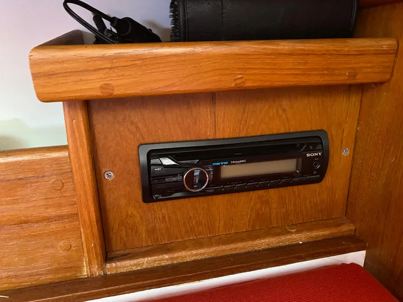 Slide: The Image of Built-in Sony stereo system in a 2014 Com-Pac 27 sailboat's wooden interior. - 17