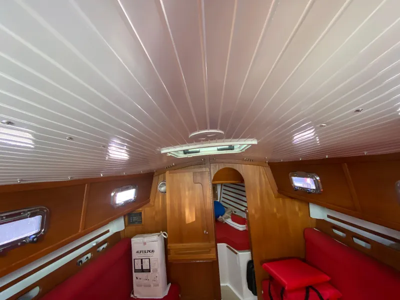 Slide: The Image of Interior cabin of 2014 Com-Pac 27 sailboat with red seating and wooden finishes. - 18