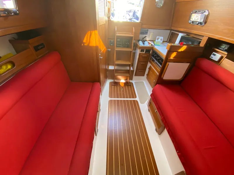 Slide: The Image of Interior of 2014 Com-Pac 27 sailboat with red seating and wooden cabinetry. - 19