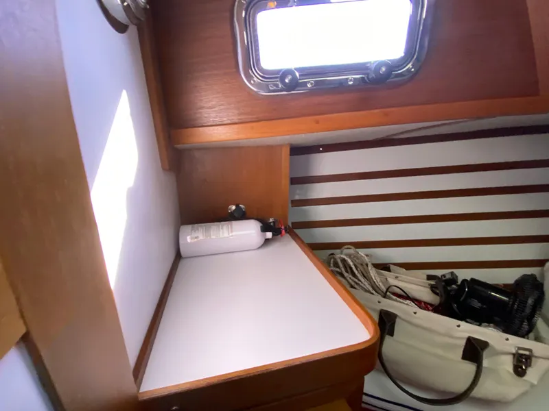 Slide: The Image of Com-Pac 27 sailboat interior, 2014 model, featuring a compact workspace and storage area. - 22