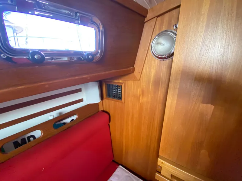 Slide: The Image of Interior cabin of 2014 Com-Pac 27 sailboat with wooden finish and red seating. - 25